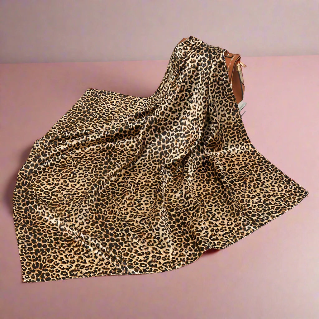 All Leopard Silk Square Scarf with a purse behind it for size reference.