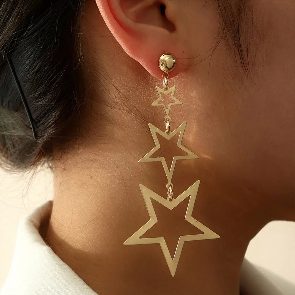 A showcasing of the gold version of the Kpop Inspired Triple Sar Drop Earrings on a female model in her ear to give speculation of the length. 