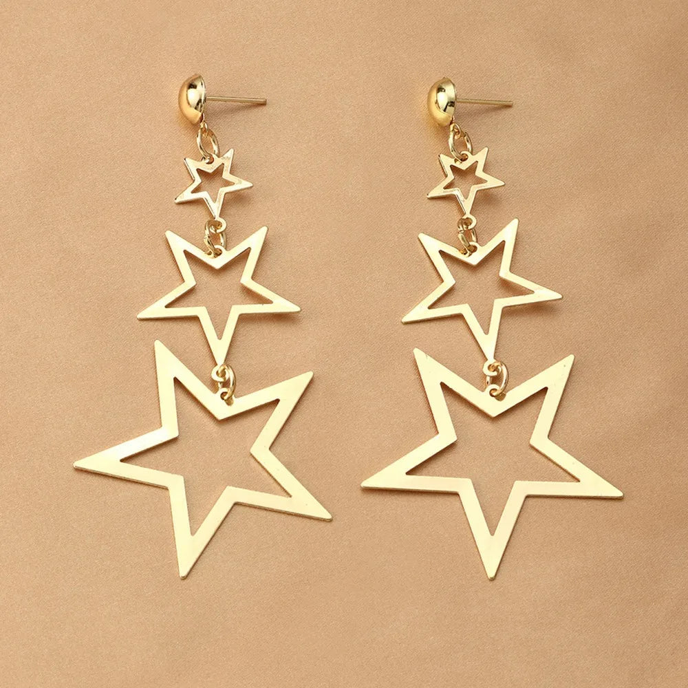 A showcasing of the gold version of the Kpop Inspired Triple Star Drop Earrings laid flat.