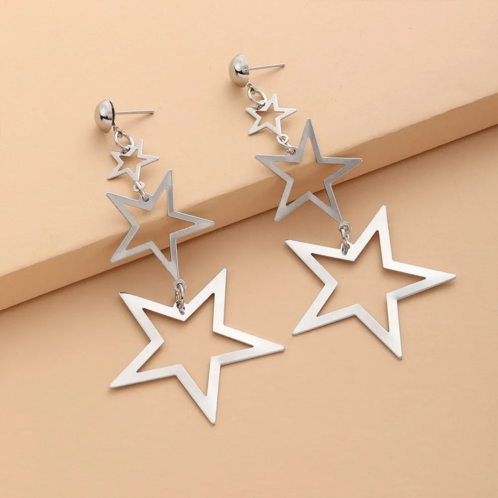 A showcasing of the silver version of the Kpop Inspired Triple Star Drop Earrings laid flat.