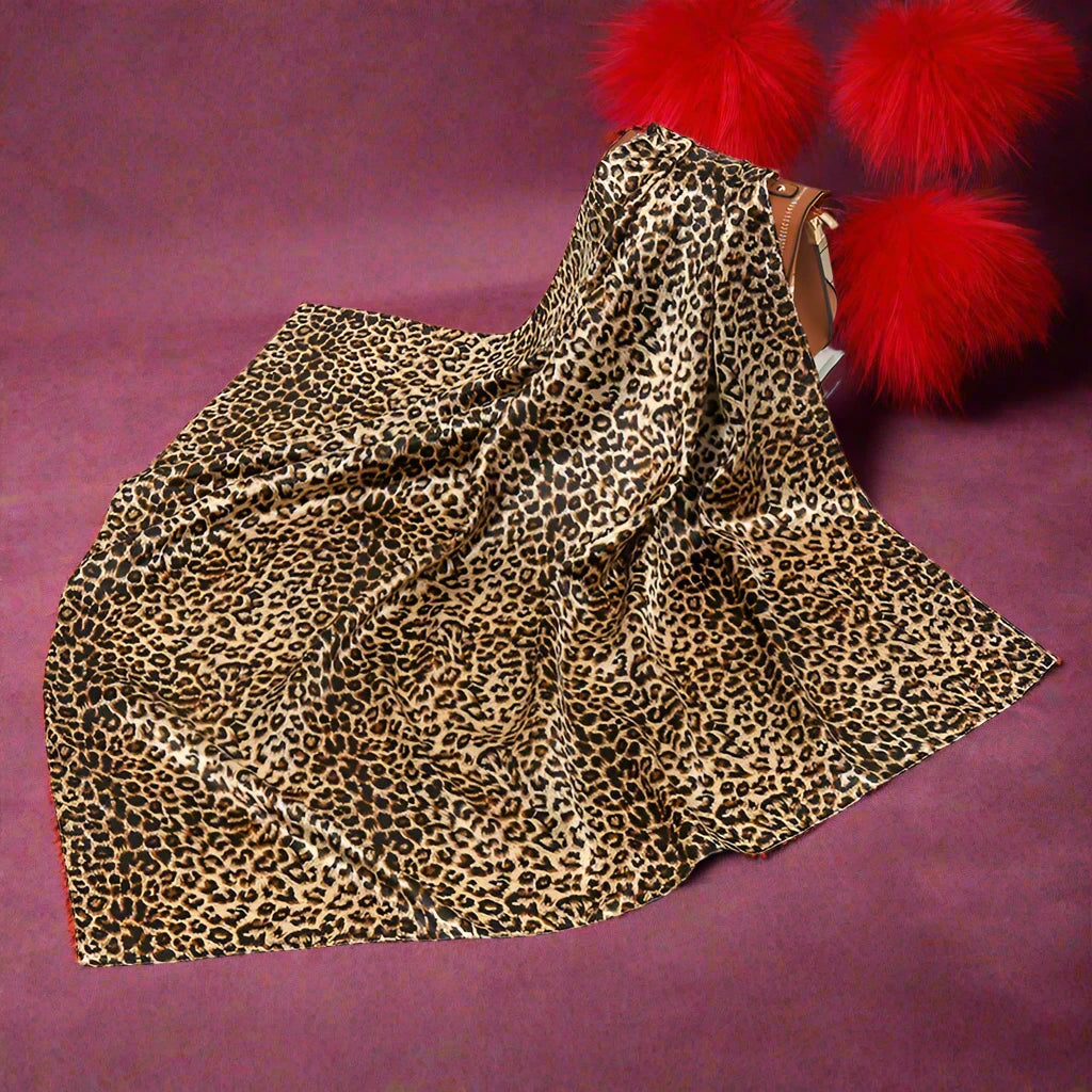 All Leopard Print Square Scarf with a purse behind it for a size reference. 