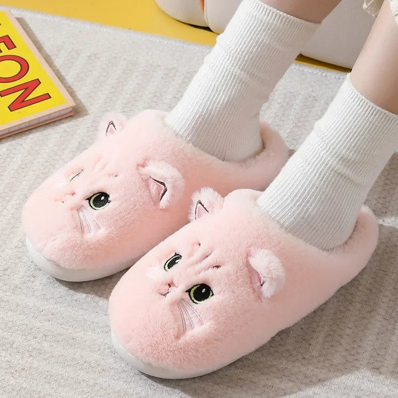 A showcase of the Pink Fuzzy Cat House Slippers on a pair of feet wearing white socks. This pink is a light shade of pink.