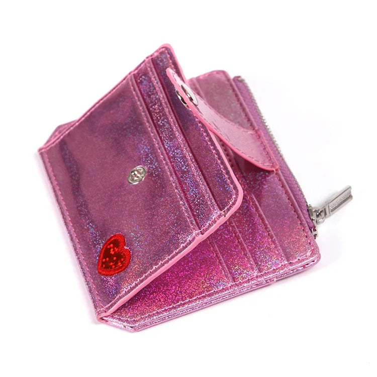 A showcasing of the Pink Glitter Wallet with a red heart empty so you can see the different slots and pockets. 